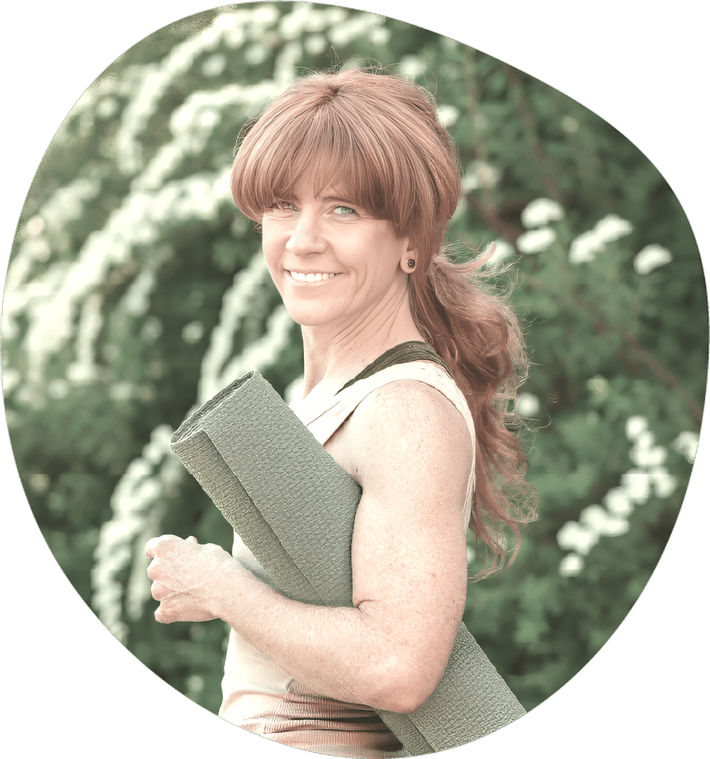 Portrait of yoga teacher holding a rolled mat outdoors, smiling